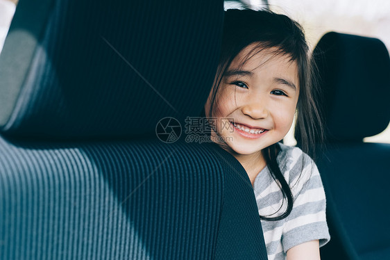 坐在汽车后座上微笑的女孩图片
