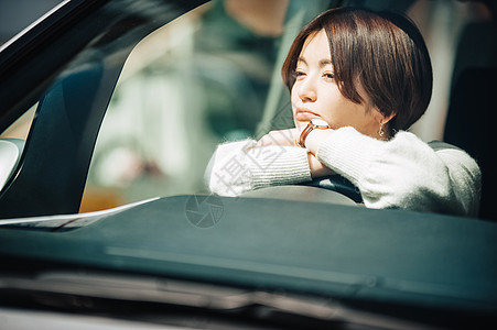 趴在车内发呆的女士图片