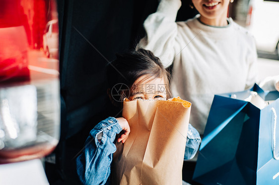 用购物袋将脸遮住的女孩图片