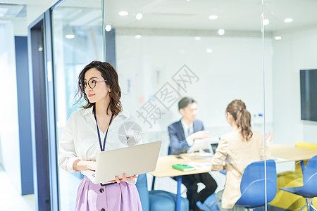 会议室外拿电脑的职场白领女性图片