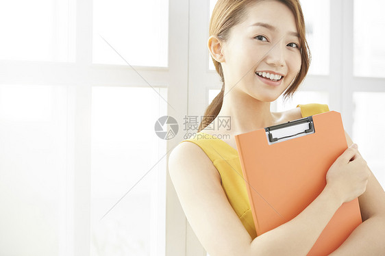 青年职业女性抱着文件夹图片