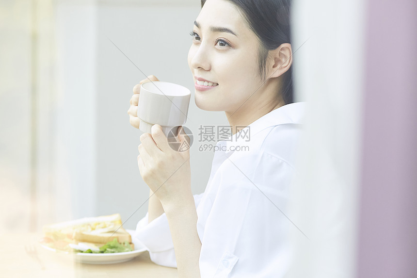吃面包喝茶的年轻女孩图片
