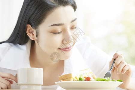 吃面包喝茶的年轻女孩图片