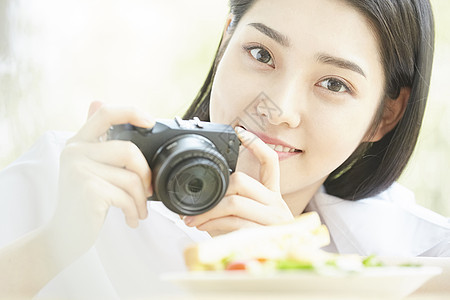 拿相机拍食物的居家女孩图片