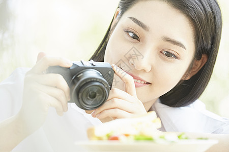 拿相机拍食物的居家女孩图片