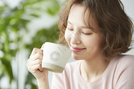 拿着水杯微笑的年轻女子图片