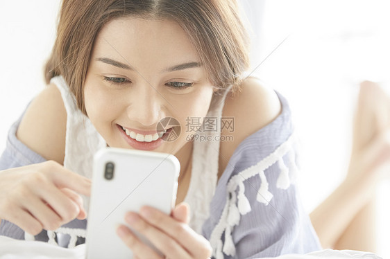 美女在床上打电话玩手机图片