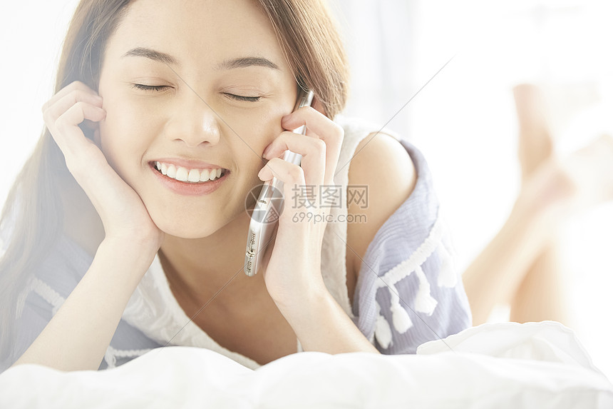 美女在床上打电话玩手机图片