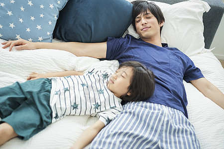 朋友放松的家人父母和孩子的生活方式床图片