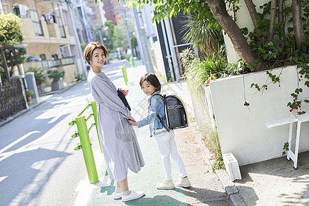 年轻妈妈接小男孩放学回家图片