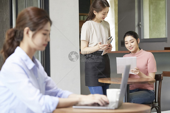 咖啡馆点单的年轻女子图片