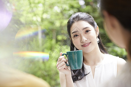 拿着咖啡微笑的年轻女子图片