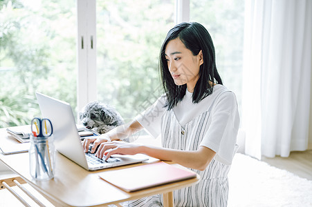 居家办公养宠物狗的女人图片