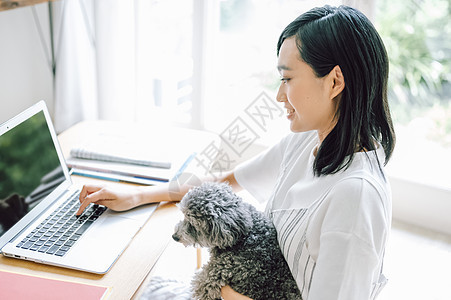 居家办公养宠物狗的女人图片