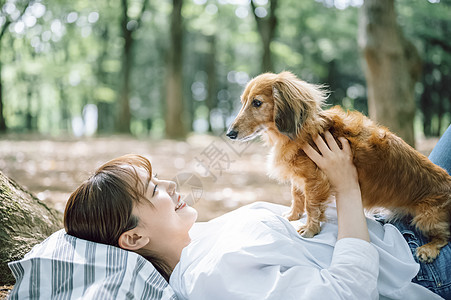 公园里带着宠物狗的女人图片