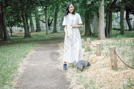 公园里遛狗的年轻女子图片