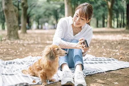 和狗狗一起郊游的年轻女子图片