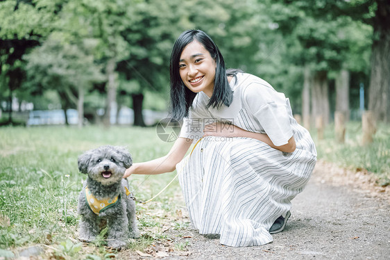 带着狗狗户外散步郊游的年轻女子图片