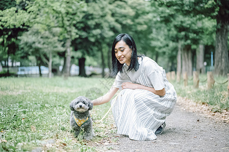 带着狗狗户外散步郊游的年轻女子图片