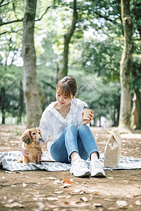 公园里带着宠物狗的女人图片