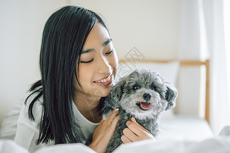 室内微笑的女人抱着宠物狗图片