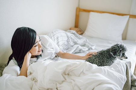 室内微笑的女人抱着宠物狗图片