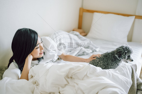 室内微笑的女人抱着宠物狗图片