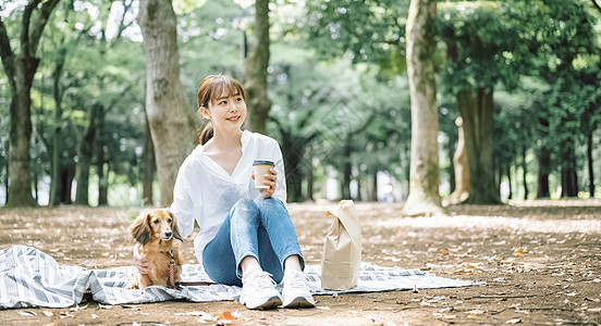 公园里带着宠物狗的女人图片