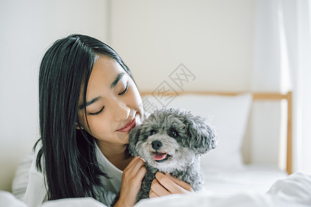 室内微笑的女人抱着宠物狗图片