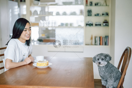 室内微笑的女人养着宠物狗图片