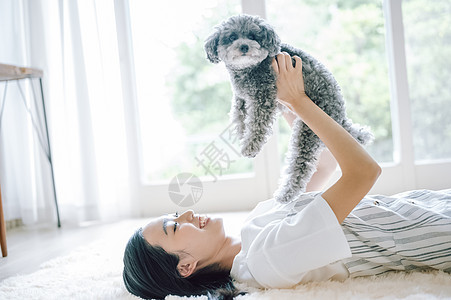 室内养着宠物狗的快乐女人图片