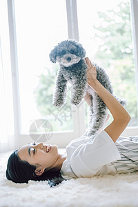 房间抱着可爱宠物狗的女人图片