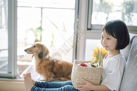 沙发上可爱的小女孩和小狗图片