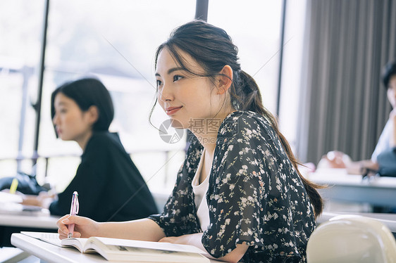 上课记笔记本的大学生图片