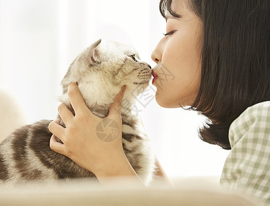 窗边的女人养着宠物猫图片