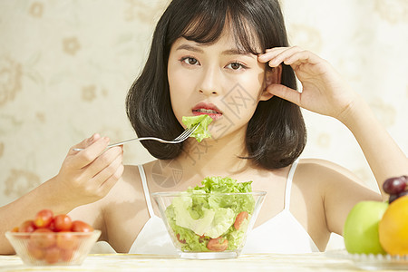 吃蔬菜沙拉的年轻女子图片