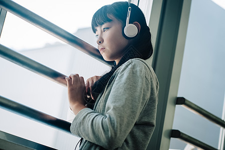 带着耳机的女学生看向窗外图片