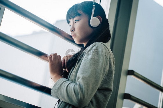 带着耳机的女学生看向窗外图片