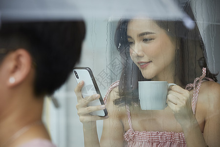 喝咖啡看手机的年轻女子图片