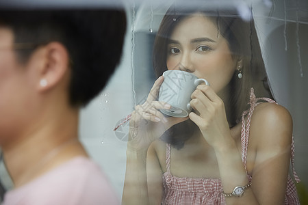 下雨天喝咖啡的青年女子图片