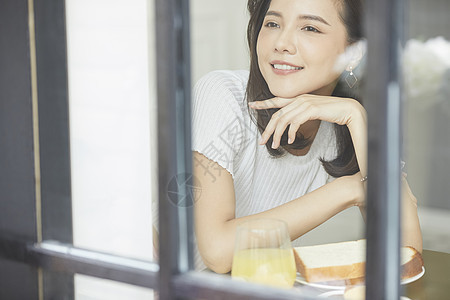 早餐看向窗外的年轻女子图片