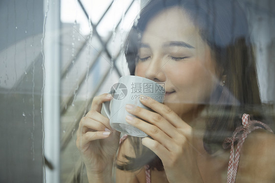 下雨天咖啡馆喝咖啡的年轻女子图片