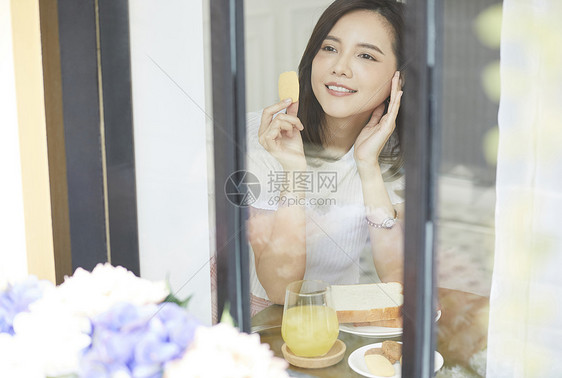 吃下午茶看向窗外的年轻女子图片