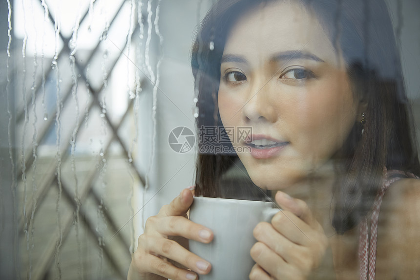 下雨天喝咖啡的年轻女孩图片