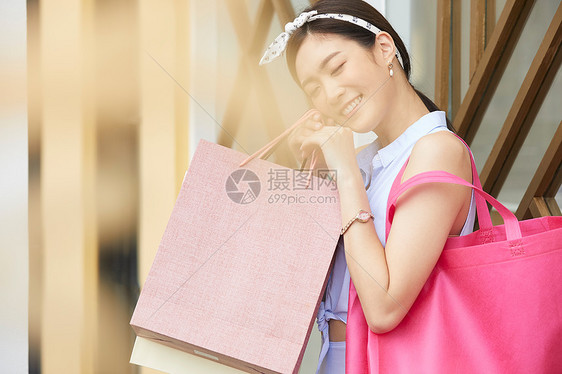 提着购物袋开心的年轻女子图片