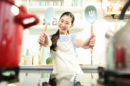 愉快的女人在厨房做美食图片