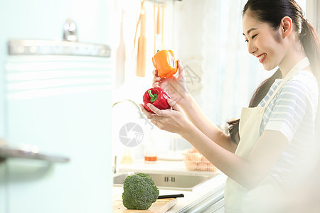 愉快的女人在厨房做美食图片