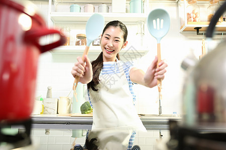 愉快的女人在厨房做美食图片