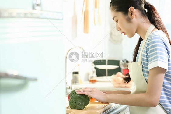 愉快的女人在厨房做美食图片