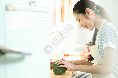 愉快的女人在厨房做美食图片